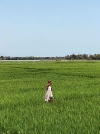 Girl on field against clear sky