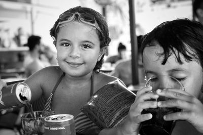 Portrait of smiling girl with brother at restaurant
