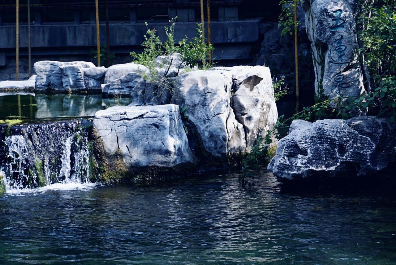 water, waterfront, rock - object, reflection, tranquility, tranquil scene, scenics, rippled, beauty in nature, stone material, day, nature, rock formation, stream, non-urban scene, water surface, natural landmark, outdoors, flowing water, formal garden, famous place, riverbank, rock, no people, non urban scene