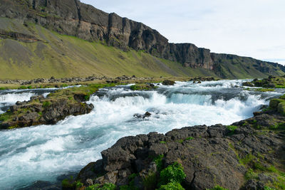 Scenic view of waterfall against sky