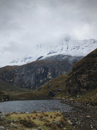 Scenic view of sea and snowcapped mountains against sky