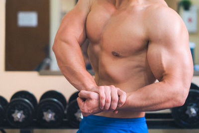 Midsection of shirtless man flexing muscles