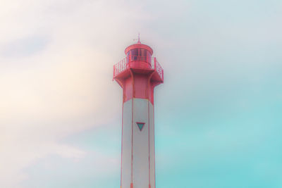 Low angle view of lighthouse by building against sky