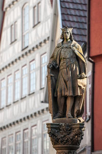 Low angle view of statue against building in city