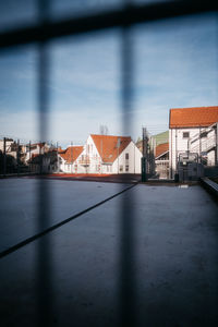 Buildings by street against blue sky