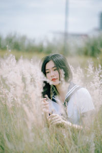 Young woman amidst plants on field