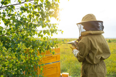 Rear view of man standing against trees