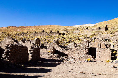 Weathered wall of old building against clear blue sky