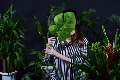 Woman holding leaves in plant