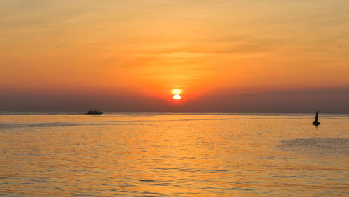 Scenic view of sea against orange sky