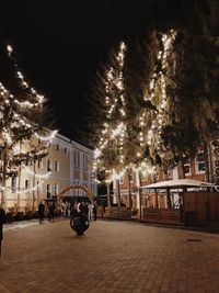 Cars on street by buildings at night