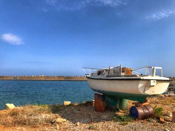 Boat moored on beach against sky