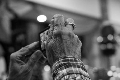 Close-up of senior person photographing through smart phone