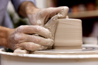 Midsection of man making pottery at workshop