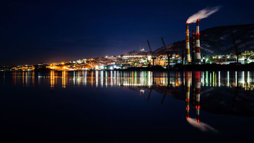Illuminated factory against sky at night