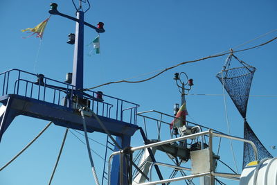 Low angle view of crane against clear blue sky