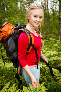 Portrait of smiling young woman standing in forest