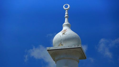 Low angle view of minaret against blue sky