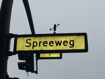 Low angle view of road sign against clear sky