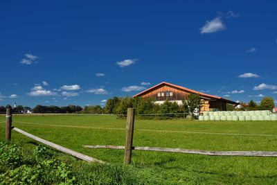 Built structure on field against blue sky