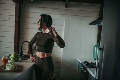 Woman drinking milk in kitchen at home