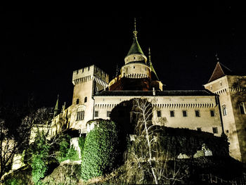 Low angle view of illuminated building against sky at night