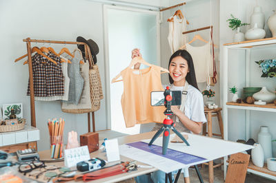 Portrait of young woman using mobile phone on table