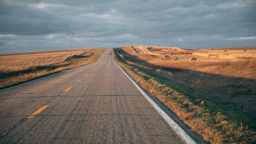 Road amidst land against sky