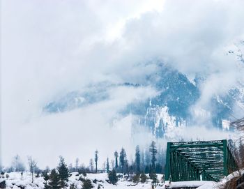 Panoramic view of snow covered trees against sky