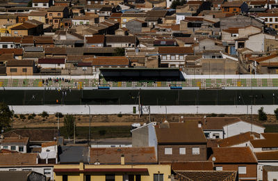 Aerial view of small town, consuegra, castilla la mancha, spain, with activities in football field