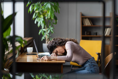 Tired businesswoman sleeping on desk in office exhausted unmotivated with monotonous tasks need rest