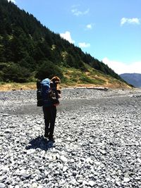 Rear view of friends standing on mountain against sky