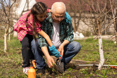 Girl with grandfather gardening outdoors