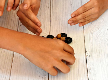 Midsection of couple holding hands on table