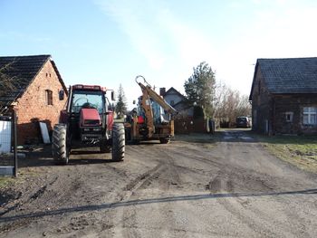 Road by buildings in city against sky