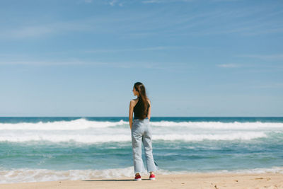 Full length of man standing on beach against sky