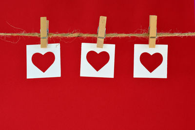 Close-up of heart shape hanging on red wall