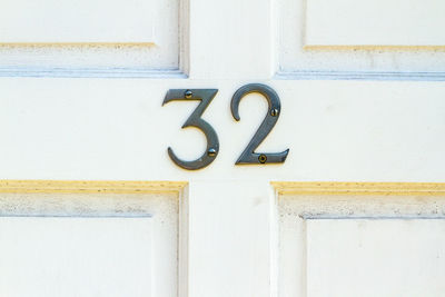 House number 32 on a white wooden front door in london 