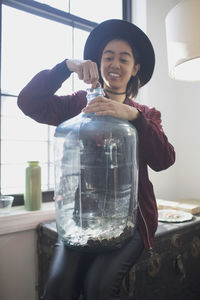 Portrait of smiling woman holding glass window