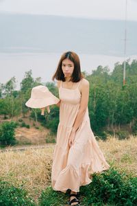 Portrait of young woman standing on field