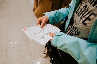 Midsection of woman holding paper