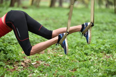 Low section of mid adult woman exercising at public park