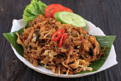 Kwetiaw or kwetiau, fried rice flat noodles with chicken, meatballs, and various vegetables.