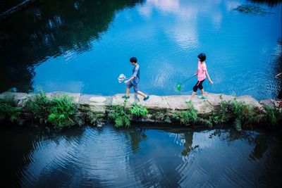 High angle view of boy jumping in lake