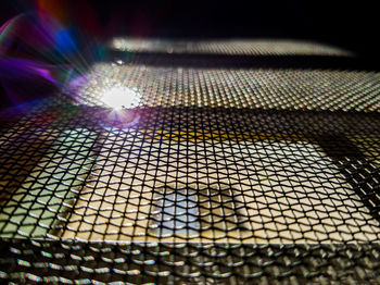 Close-up of illuminated metal grate