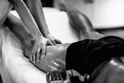 Woman massaging man lying on bed