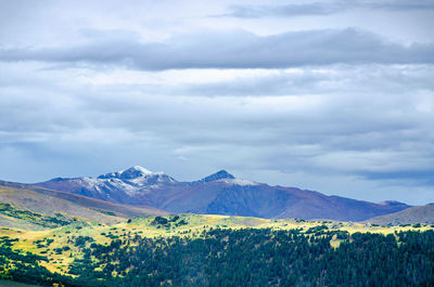 Scenic view of land and mountains against sky