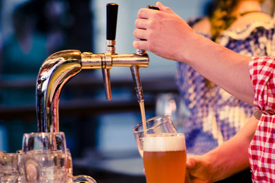 Close-up of hand pouring drink in glass