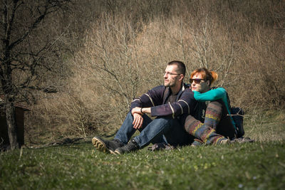 Portrait of a smiling young couple sitting on grass