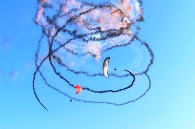 Low angle view of airplane flying against blue sky